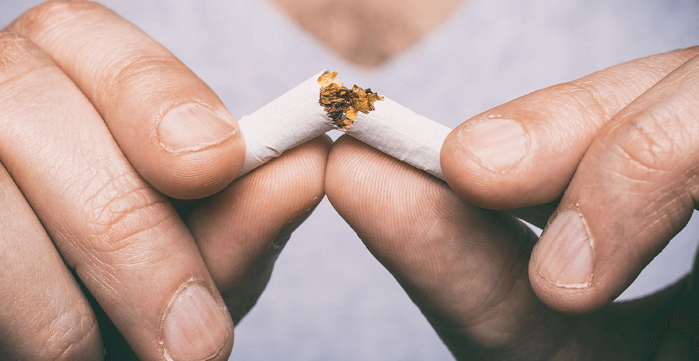 Closeup of a cigarette being broken in half.