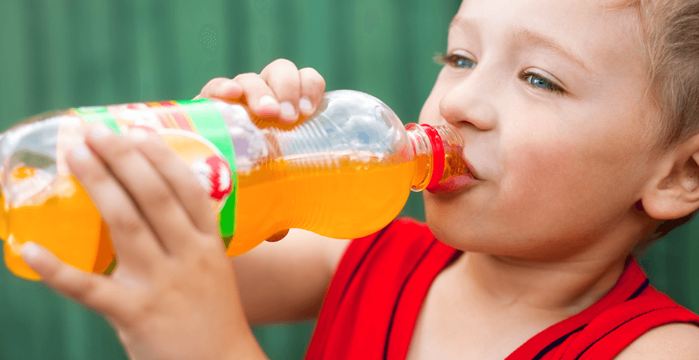 Photo of a boy drinking a sugary drink.