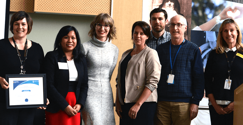 Gina Trinidad, Chef des opérations en santé de l'ORSW (deuxième de la gauche) présente le prix d'innovation en santé à Cara Windle, Maria Froese, Susan Bowman, Daryl Dyck, Kathleen Klaasen et Ivan Garcia (arrière) comme représentants de l'équipe de soins des plaies du Deer Lodge Centre.