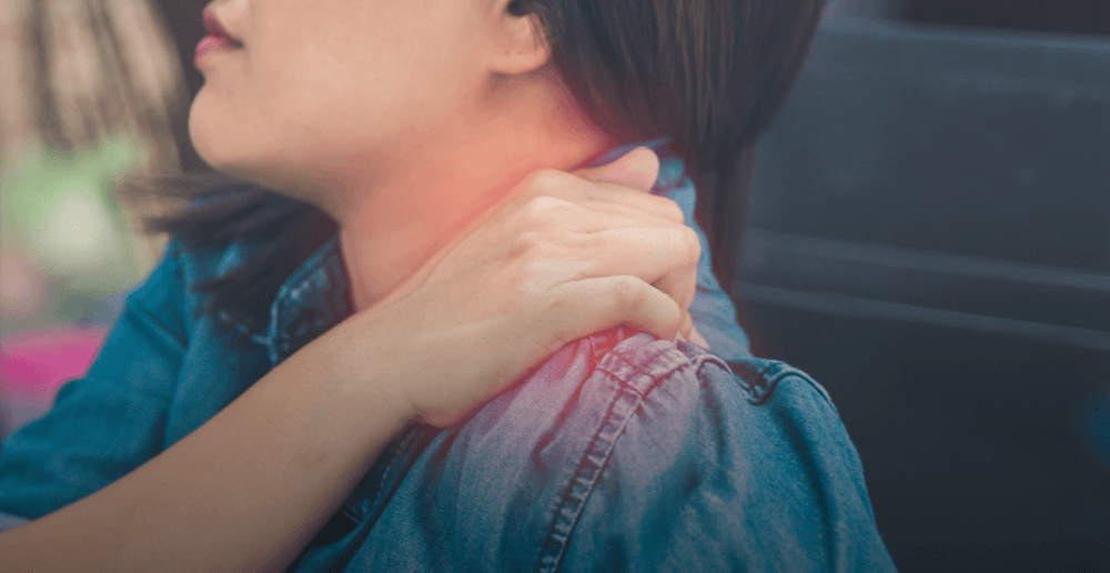 Photo of a woman holding her shoulder