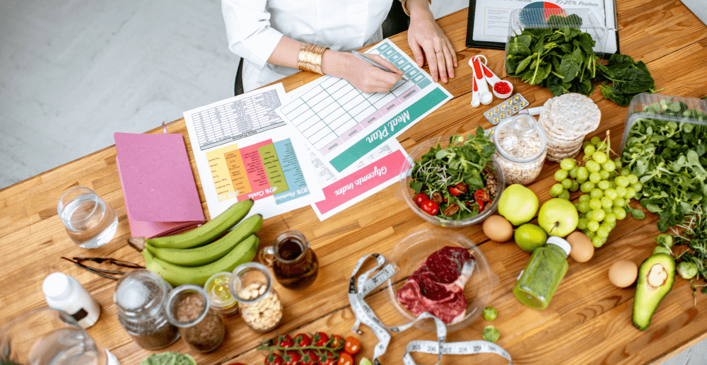 Photo of a dietitian sitting at a table filled with healthy food