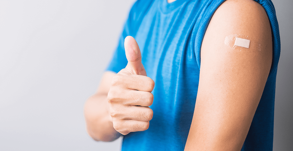 Photo of a man who just got his flu shot giving a thumbs-up.