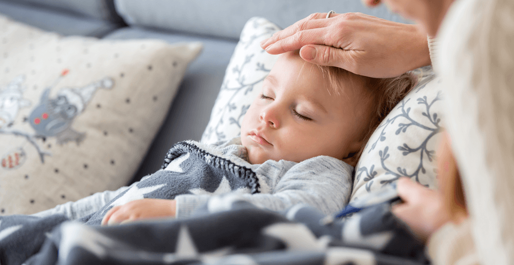 petit garçon malade avec inhalateur pour le traitement de la toux. enfant  malade faisant de l'inhalation sur son lit. saison de la grippe.  intervention médicale à domicile. intérieur et vêtements aux couleurs