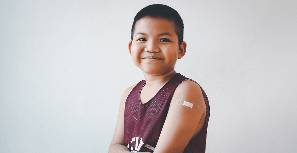 Photo of a boy showing his arm after getting COVID-19 vaccine